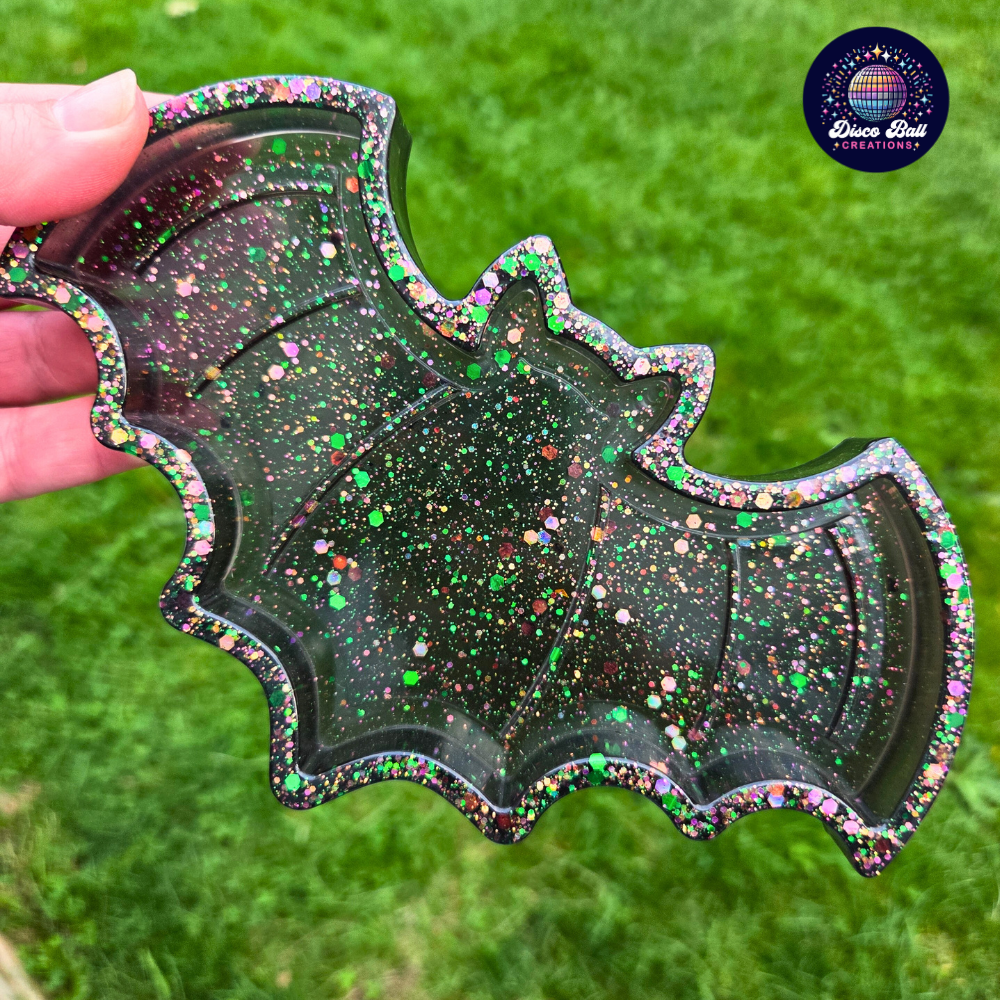 Black with Glitter Bat shaped trinket tray held by a hand on a grassy background