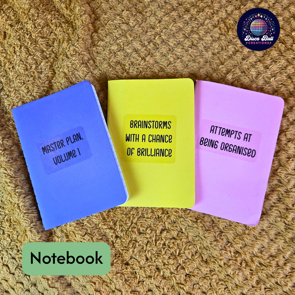 Three colourful notebooks with humorous text on a textured surface