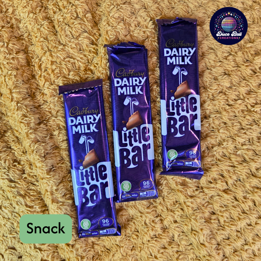 Three chocolate bars on a textured surface with 'Snack' label.